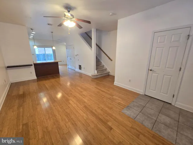 a view of a room with wooden floor and ceiling fan
