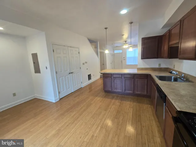 a kitchen with wooden floors and wooden cabinets