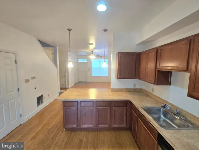 a kitchen with stainless steel appliances granite countertop a sink a stove and a wooden floors