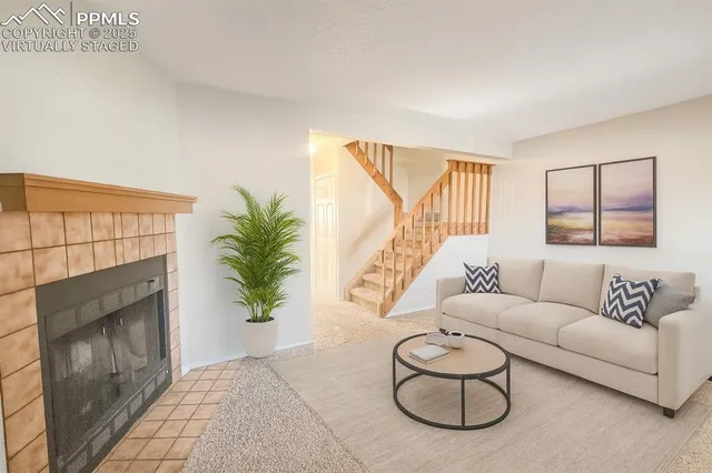 a living room with furniture a fireplace and potted plants