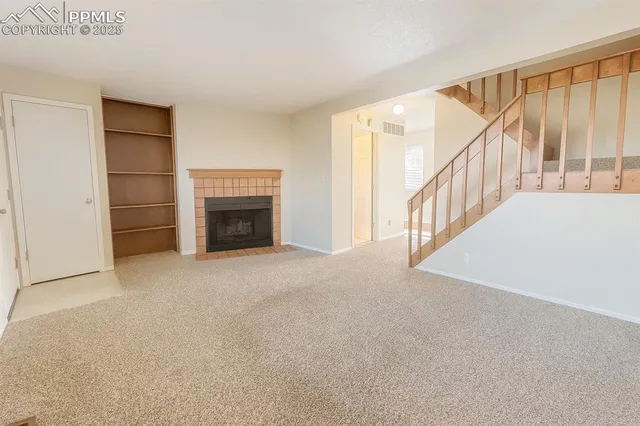 a view of empty room with fireplace and stairs