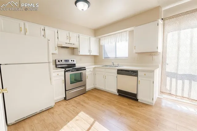 a kitchen with white cabinets and white appliances