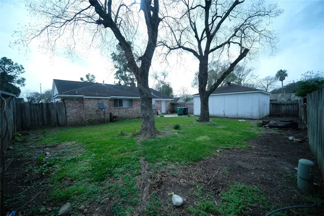 a view of a house with backyard and a tree
