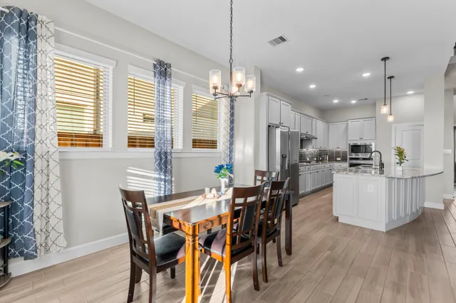 a kitchen with stainless steel appliances a refrigerator and a wooden floor