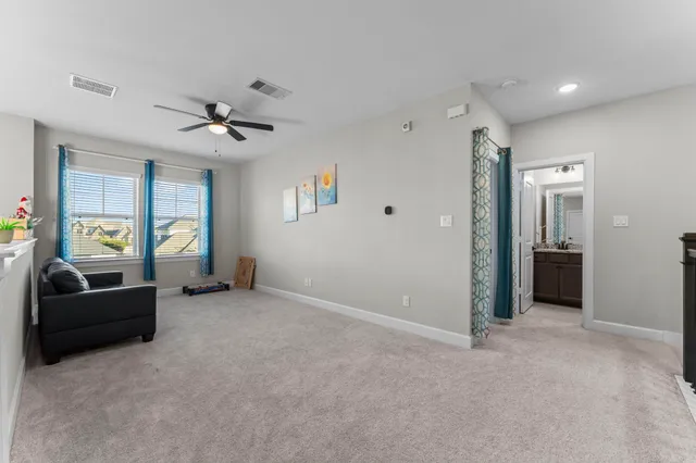 a bedroom with a bed and a chandelier fan