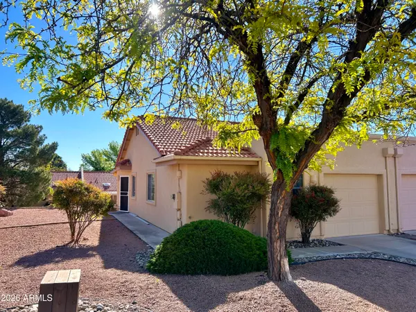 a front view of a house with a tree