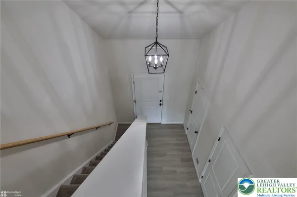 a view of a hallway with wooden floor and staircase