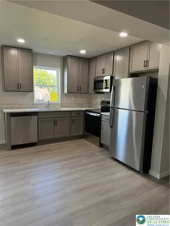 a kitchen with stainless steel appliances granite countertop a refrigerator and a sink