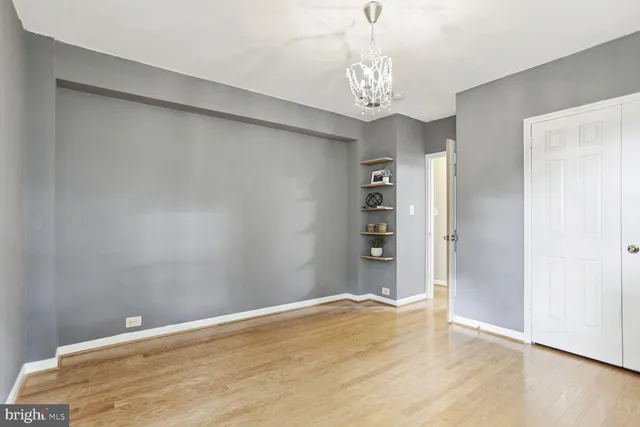 a view of a big room with wooden floor and chandelier