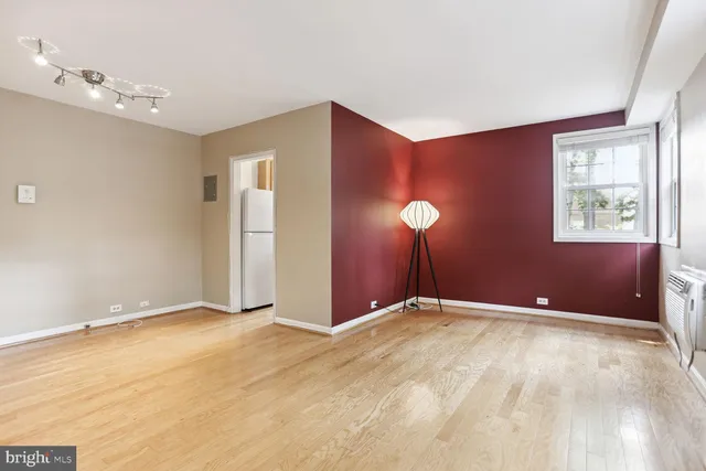 a view of an empty room with window and a ceiling fan