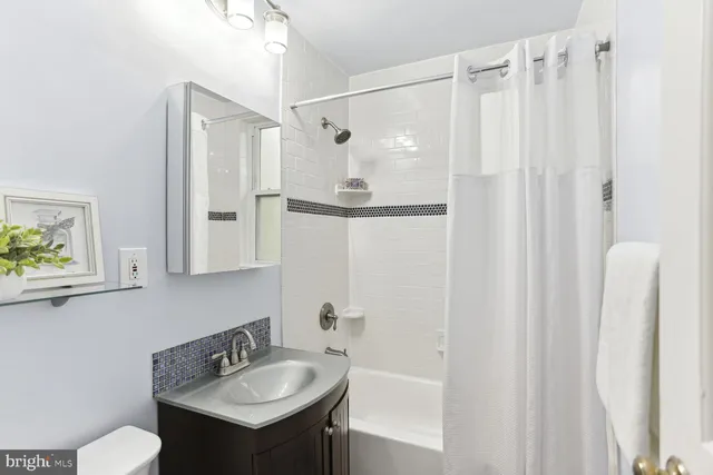 a bathroom with a sink a mirror and a shower curtain