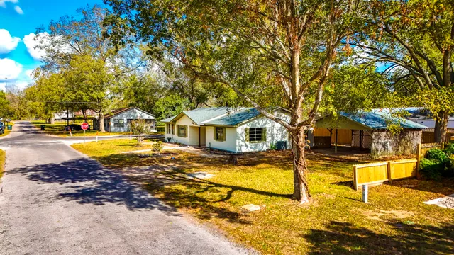 a view of swimming pool with lawn chairs under an umbrella