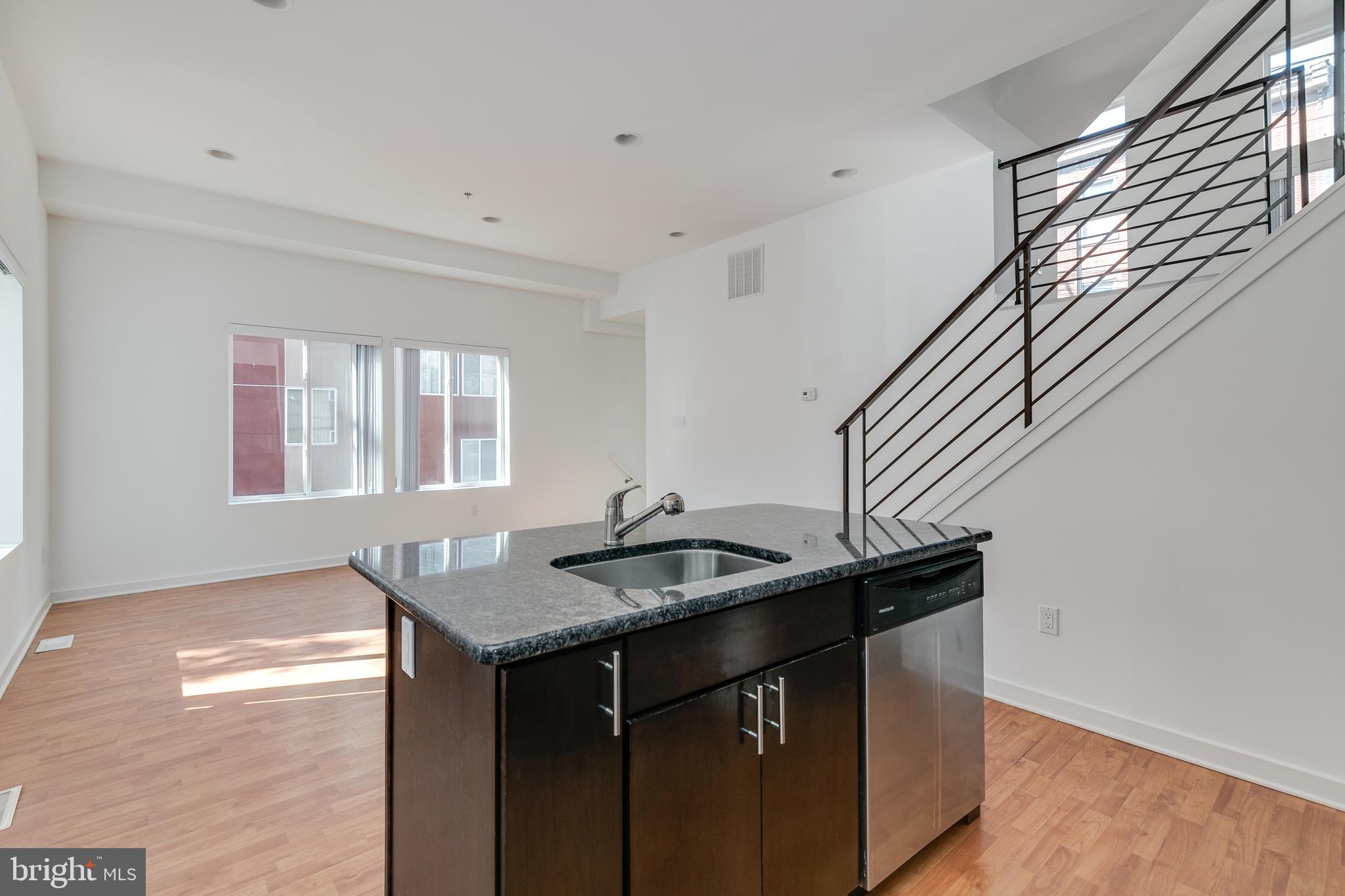 220 West George Street, Unit 224 Philadelphia, PA 19123 - Photo 14 of 56 a kitchen with granite countertop kitchen island a sink a stove and a window
