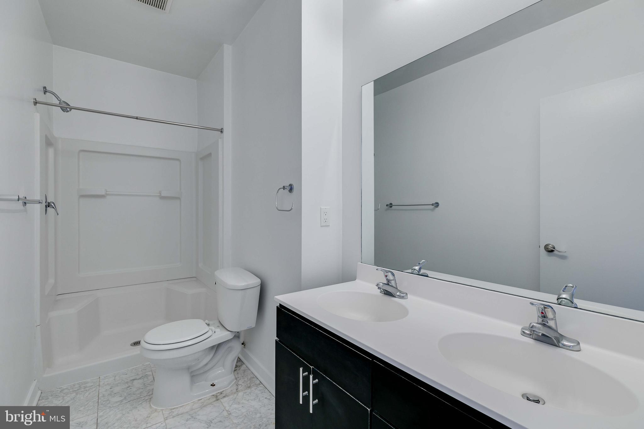 220 West George Street, Unit 224 Philadelphia, PA 19123 - Photo 15 of 56 a bathroom with a granite countertop sink a toilet and shower