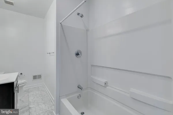 a white toilet sitting next to a shower
