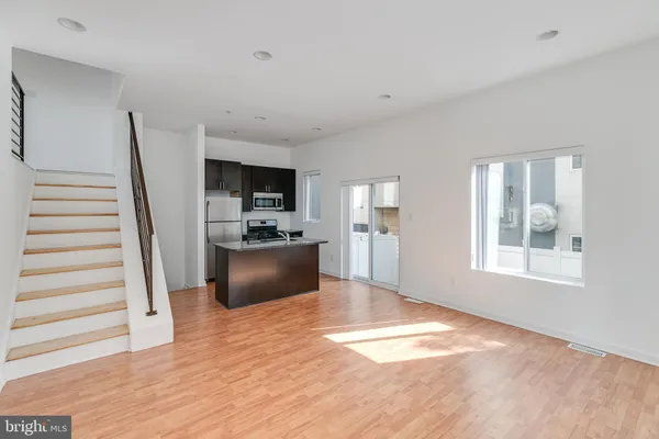 a kitchen with kitchen island granite countertop a sink and stainless steel appliances
