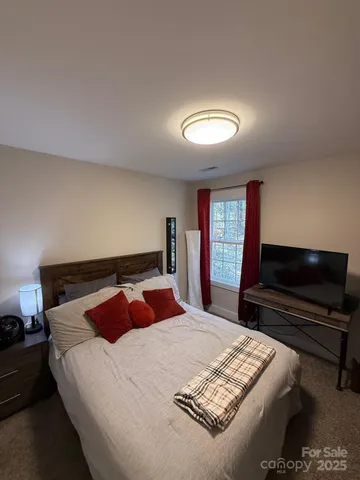 a bedroom with a bed and a television