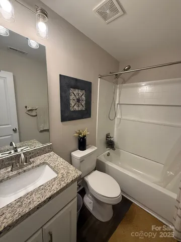 a bathroom with a granite countertop sink toilet and shower