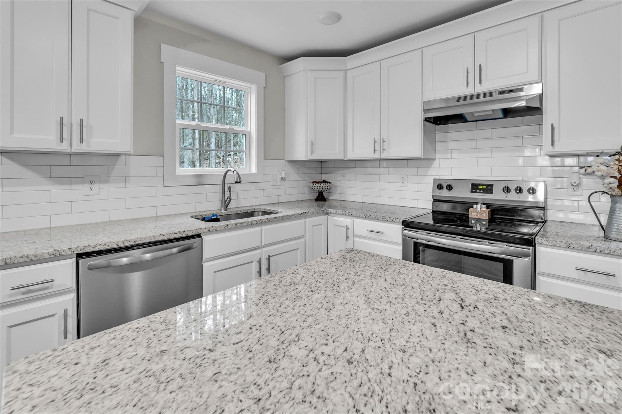 518 Lake Head Road Norwood, NC 28128 - Photo 17 of 39 a kitchen with granite countertop a sink white cabinets and stainless steel appliances