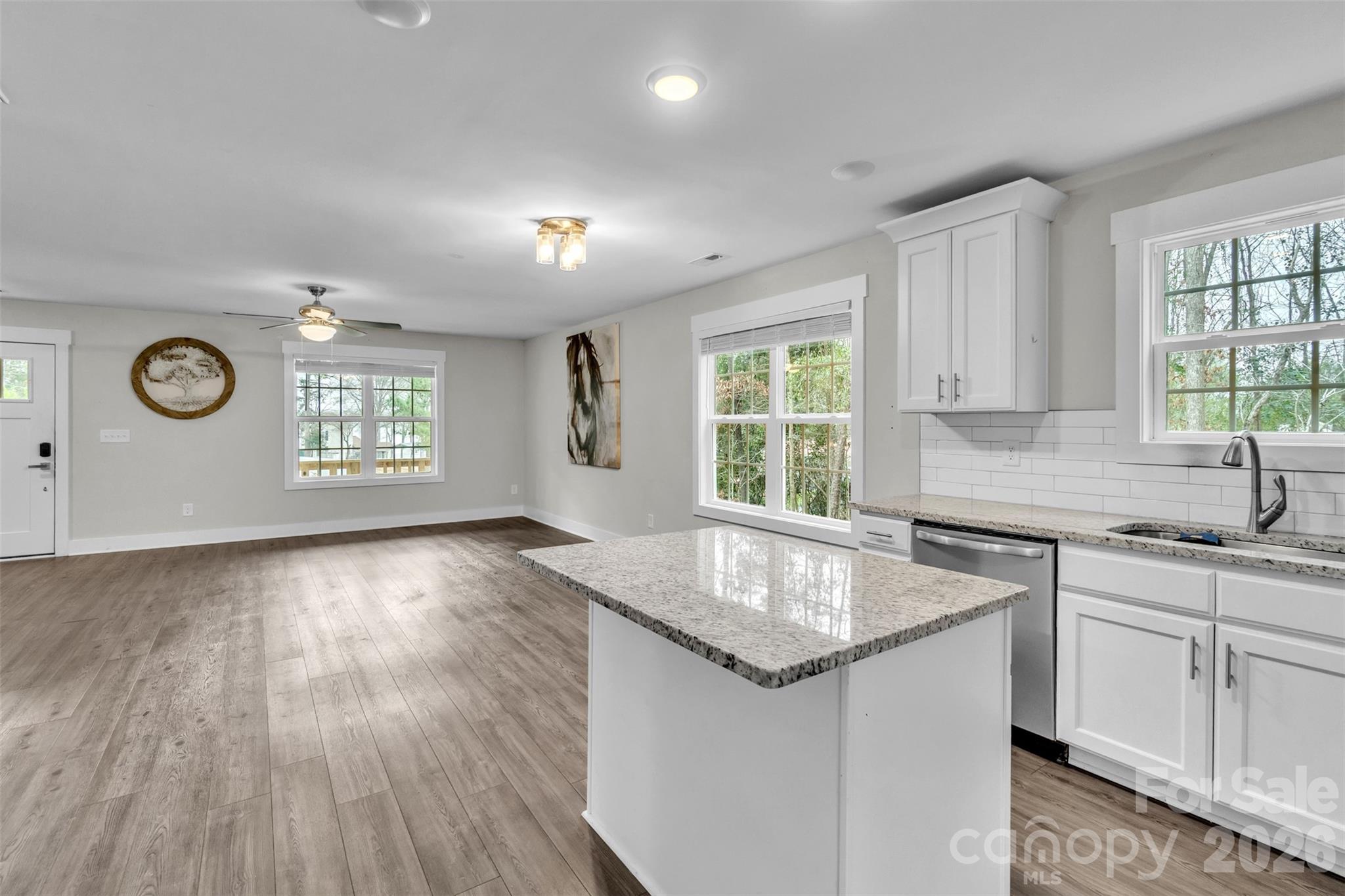 518 Lake Head Road Norwood, NC 28128 - Photo 18 of 39 a kitchen with granite countertop a oven a sink dishwasher and white cabinets with wooden floor