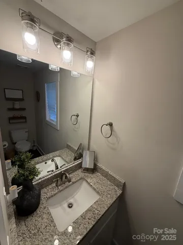 a bathroom with a granite countertop sink a toilet and shower