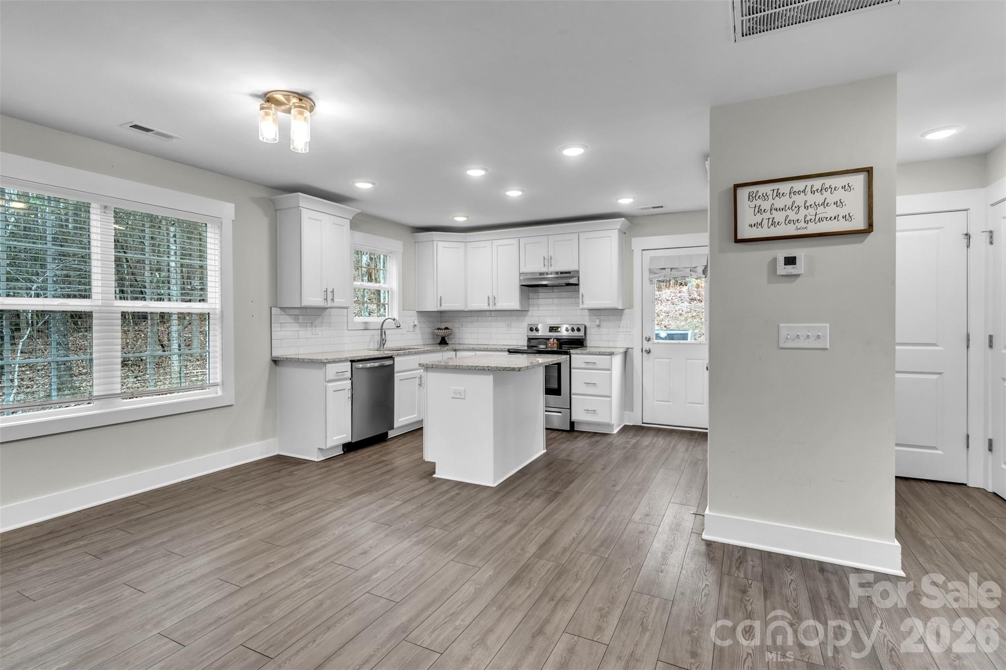 518 Lake Head Road Norwood, NC 28128 - Photo 22 of 39 a kitchen with white cabinets and wooden floor