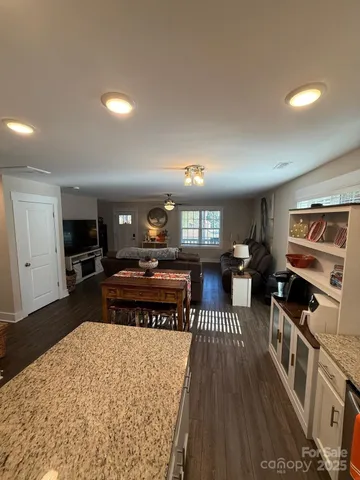 a living room with furniture a flat screen tv and kitchen view