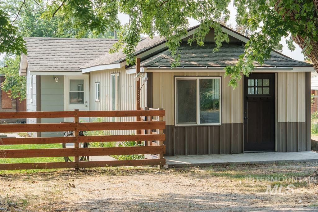 933 South Mill Road Emmett, ID 83617 - Photo 2 of 19 Compact structure featuring two-tone corrugated metal siding, a dark paneled door with grid lites, and an adjacent window