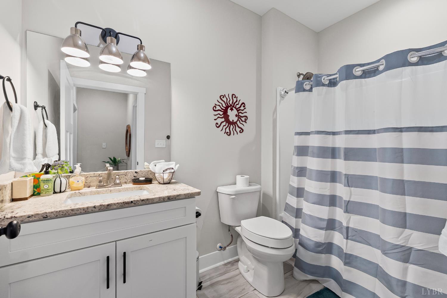 1301 Stoney Ridge Boulevard, Unit 105 Forest, VA 24551 - Photo 13 of 31 a bathroom with a granite countertop sink mirror vanity and toilet