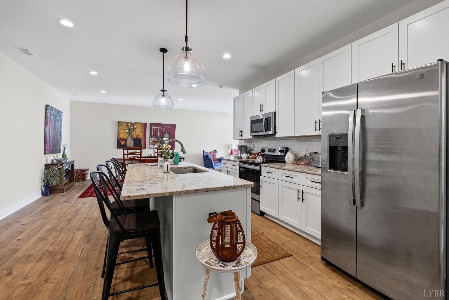 1301 Stoney Ridge Boulevard, Unit 105 Forest, VA 24551 - Photo 8 of 31 a kitchen with stainless steel appliances granite countertop a refrigerator a stove a sink a dining table and chairs with wooden floor