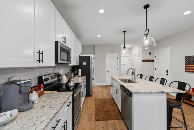 a kitchen with a sink stove and wooden floor