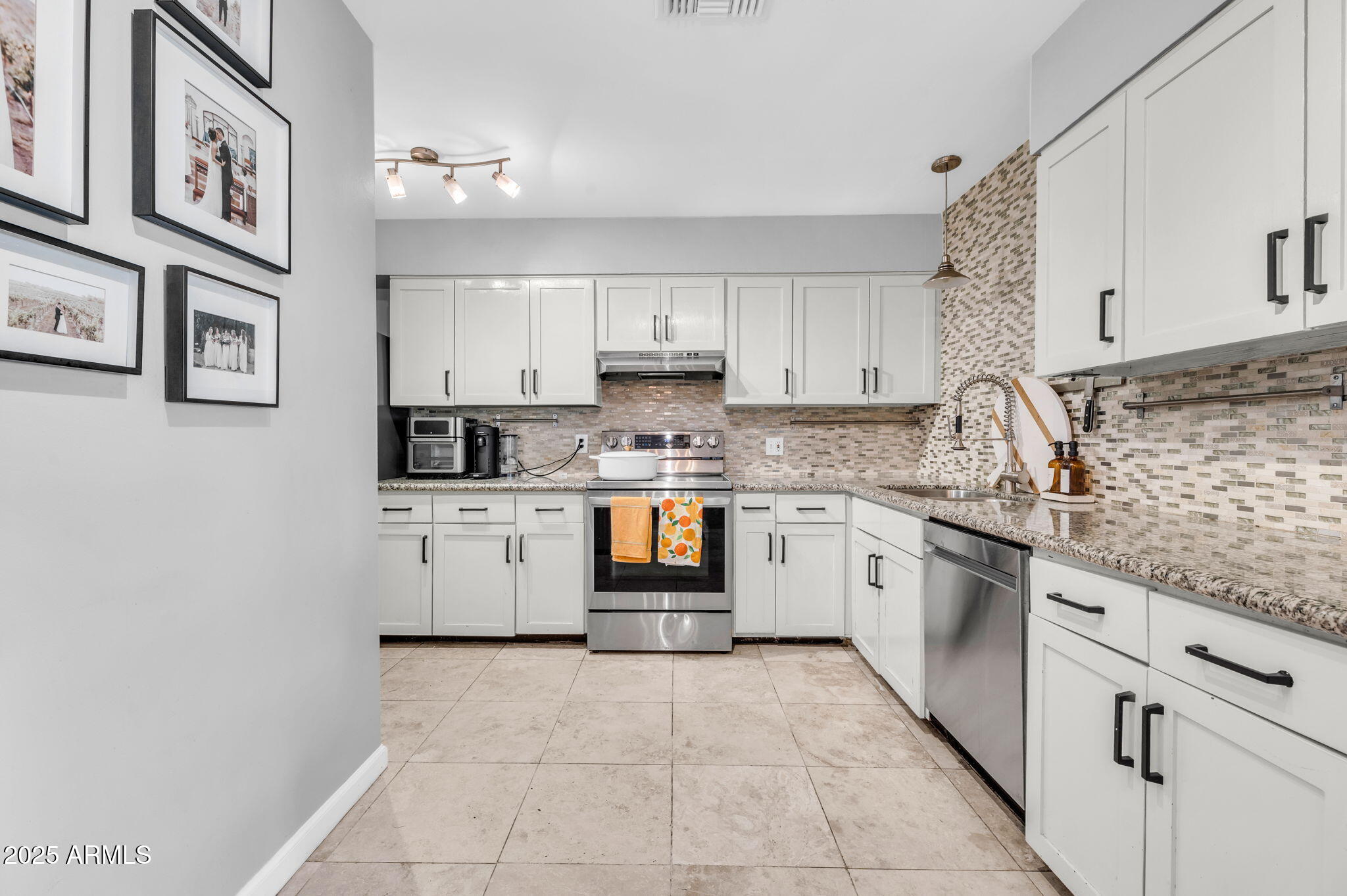 4928 East Palm Lane Phoenix, AZ 85008 - Photo 5 of 17 a kitchen with stainless steel appliances granite countertop a stove sink and cabinets