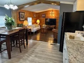 a kitchen with stainless steel appliances kitchen island granite countertop a dining table chairs and granite counter tops