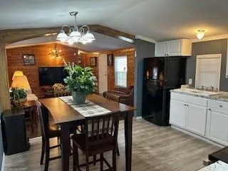 a kitchen with stainless steel appliances kitchen island granite countertop a refrigerator a stove a sink dishwasher and a dining table with wooden floor