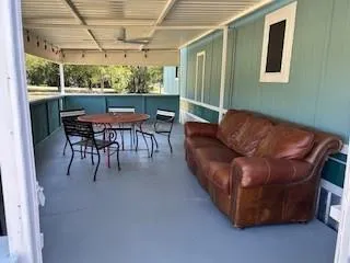 a view of a patio with table and chairs potted plants with floor to ceiling window