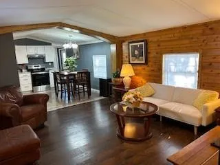 a living room with dining room and couches with potted plants