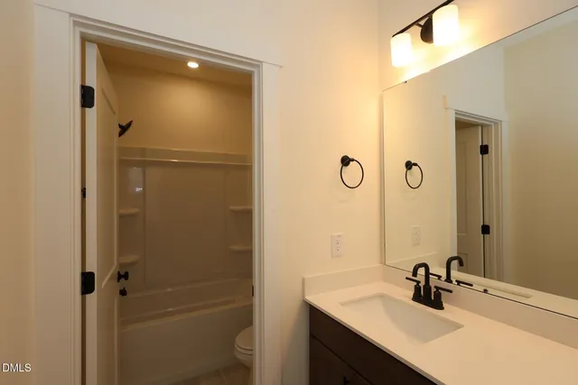 a bathroom with a sink shower and a mirror