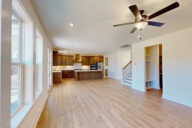 a view of an empty room with a window and fireplace