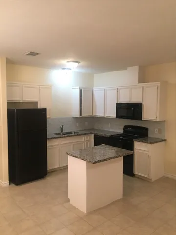 a kitchen with stainless steel appliances granite countertop a refrigerator and a stove