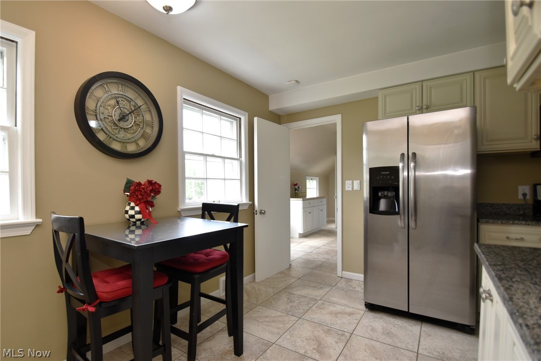 23901 Hazelmere Road Shaker Heights, OH 44122 - Photo 11 of 35 Kitchen featuring dark stone counters, light tile floors, and stainless steel refrigerator with ice dispenser