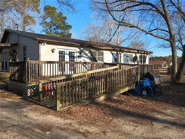 a view of a house with a small yard and wooden fence