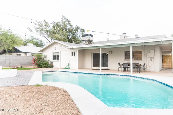 a view of a house with pool and a yard
