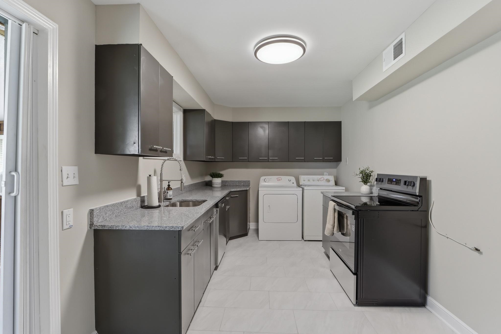 312 Fernway Road Memphis, TN 38117 - Photo 16 of 38 Kitchen with range with electric cooktop, washer and dryer, and stainless steel dishwasher