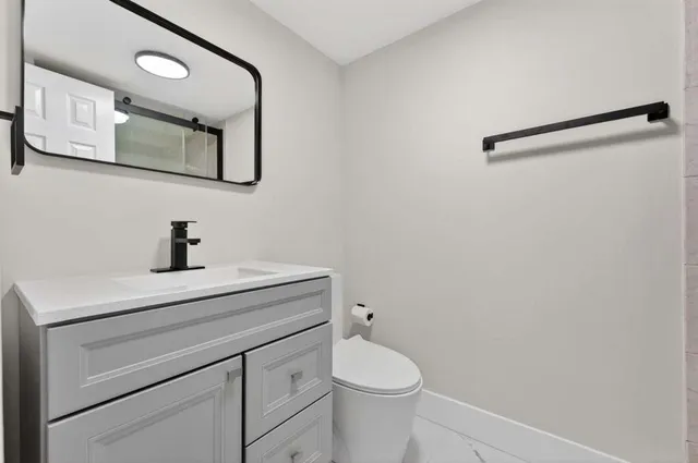 a bathroom with a toilet a sink and mirror