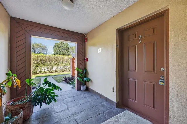 an entryway with a flower pot and a bookshelf