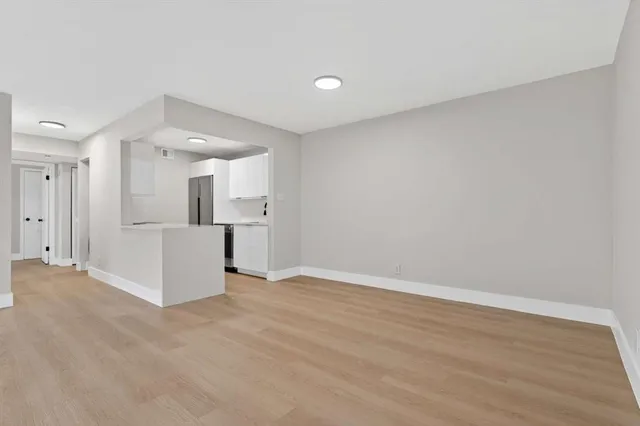 a view of a kitchen with a refrigerator and a sink
