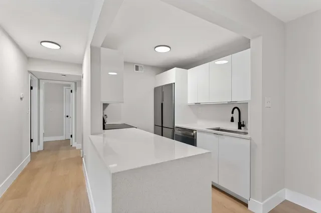 a kitchen with a refrigerator a sink and cabinets