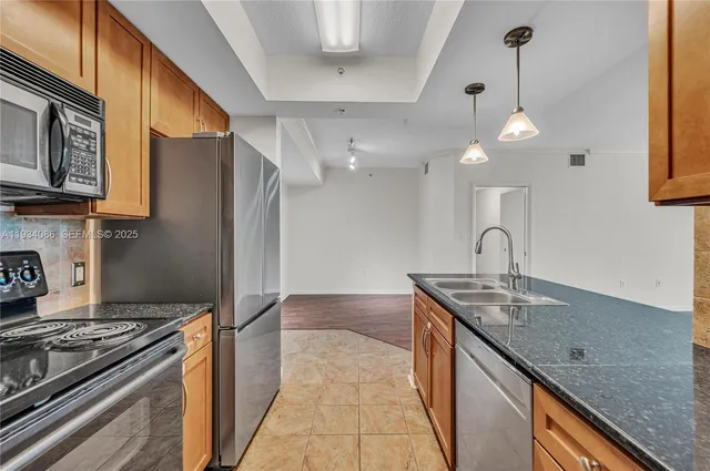 a kitchen with stainless steel appliances granite countertop a sink a stove and a wooden floors