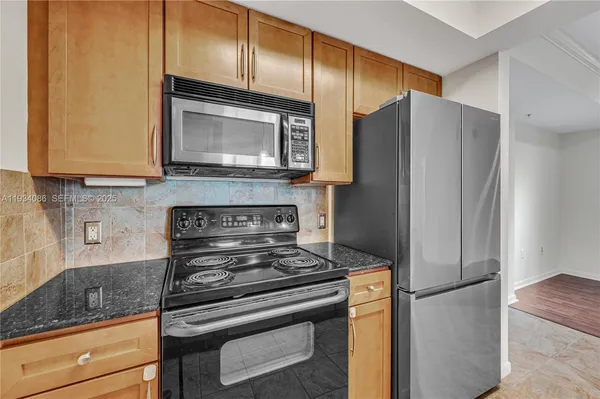 a kitchen with stainless steel appliances granite countertop a refrigerator stove and microwave