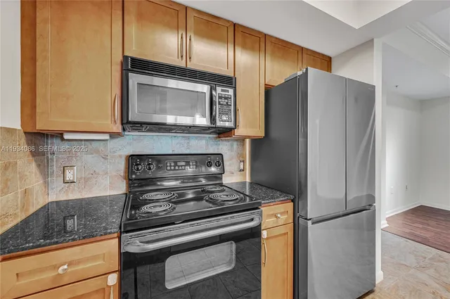 a kitchen with stainless steel appliances granite countertop a refrigerator stove and microwave